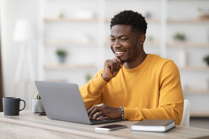 happy black guy project manager typing on laptop keyboard