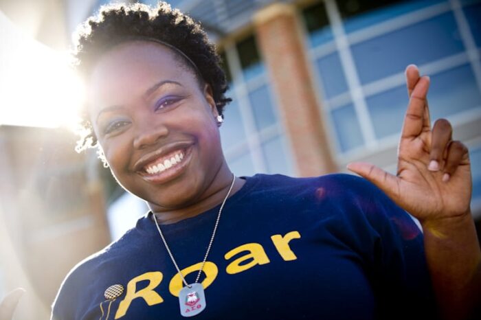 Student posing with cross gesture