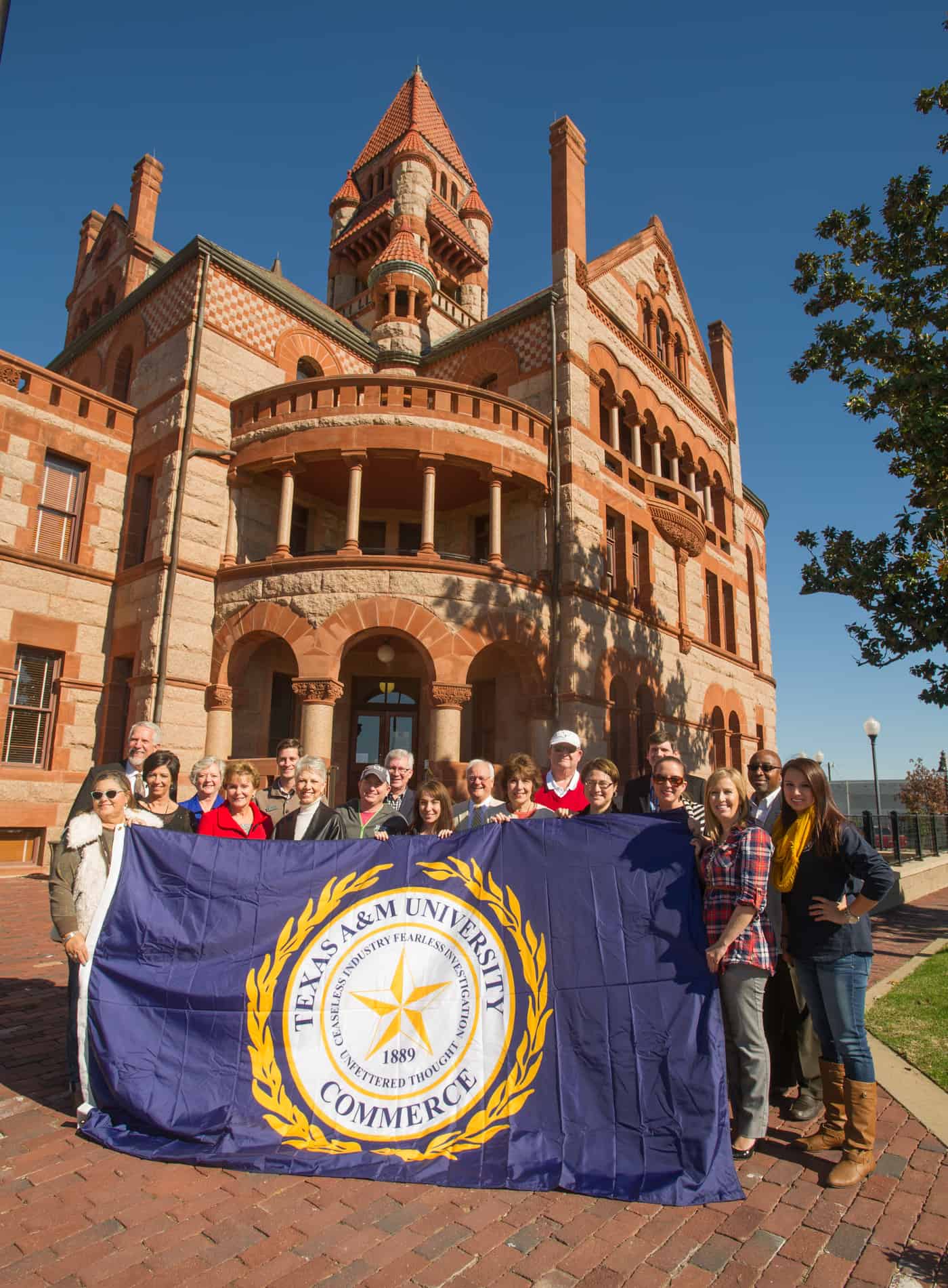 A group of individuals holding a flag in front of a building.