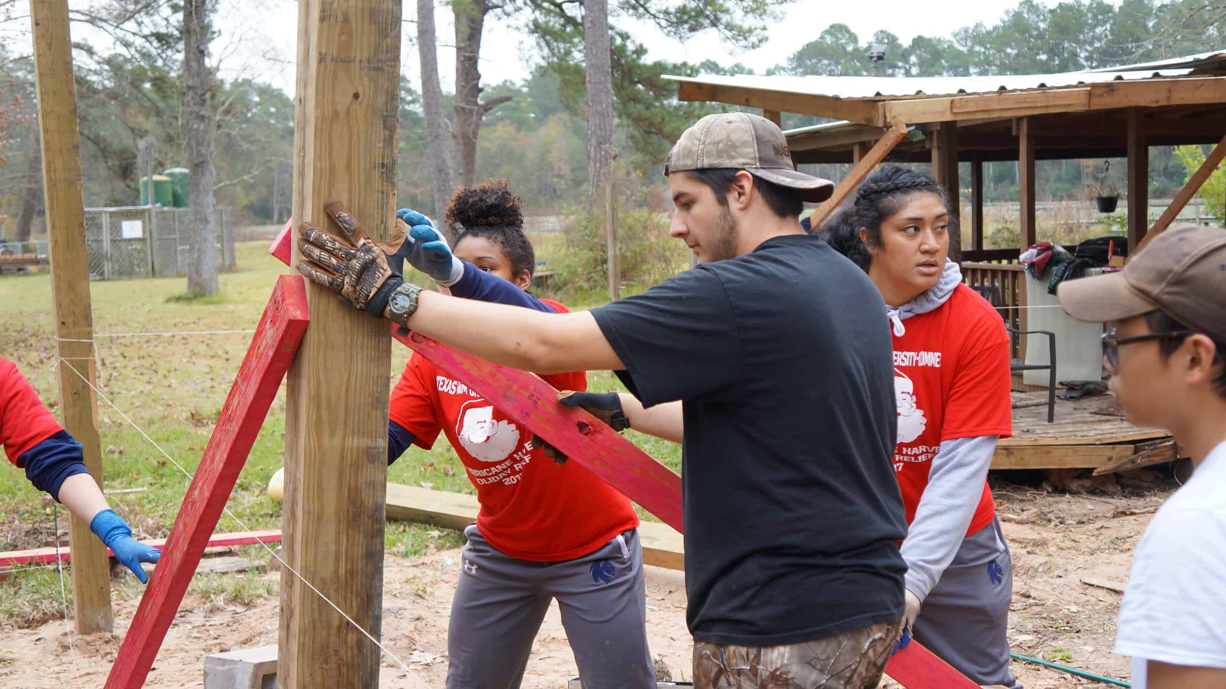 Individuals working together to place a pole