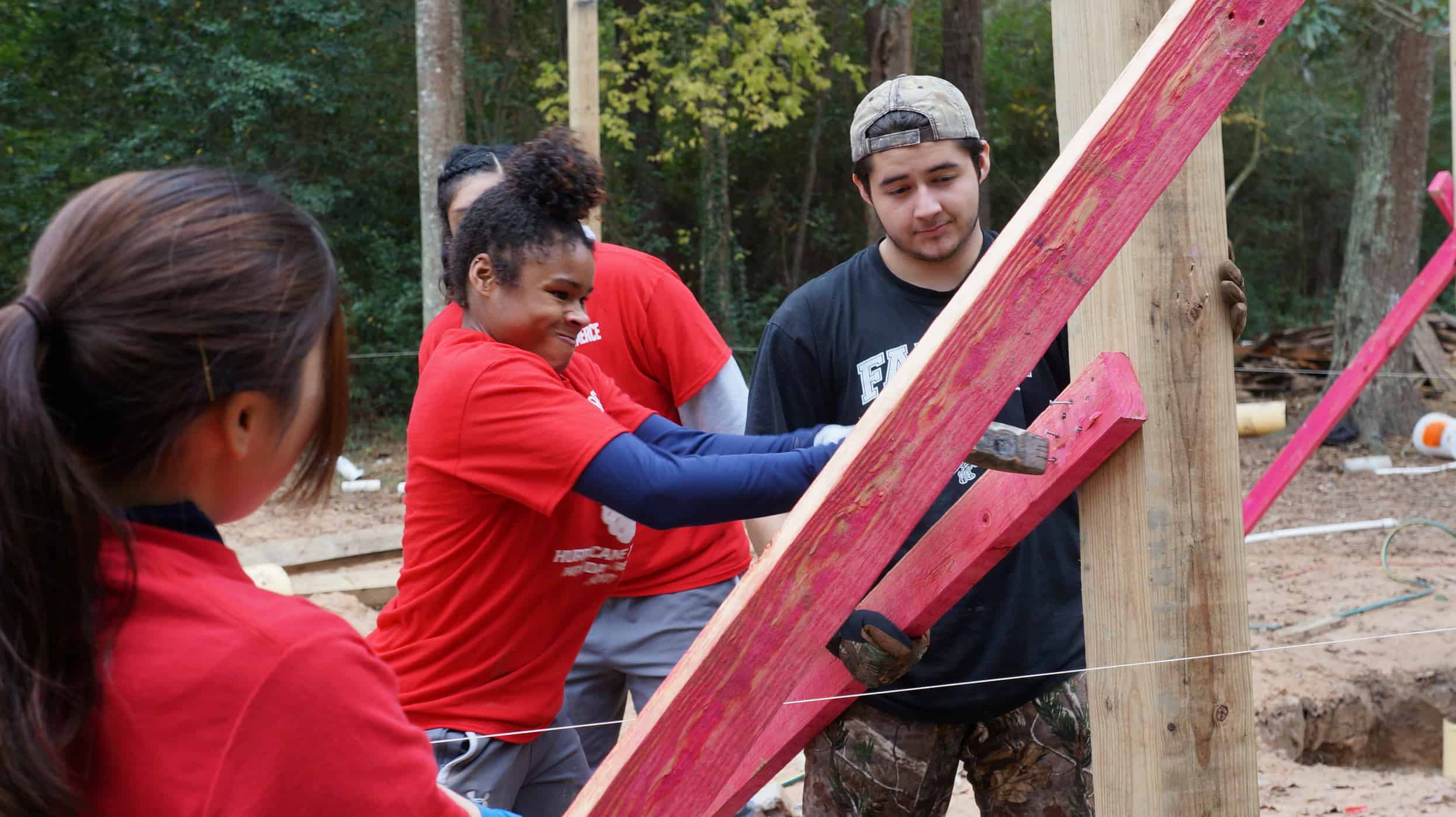 Individuals placing brackets on a pole