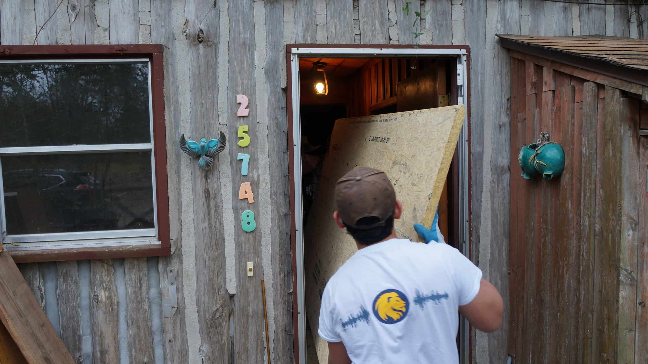 An individual carrying dry wood into a house