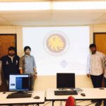 A group of 5 guys in front of a power point presentation.