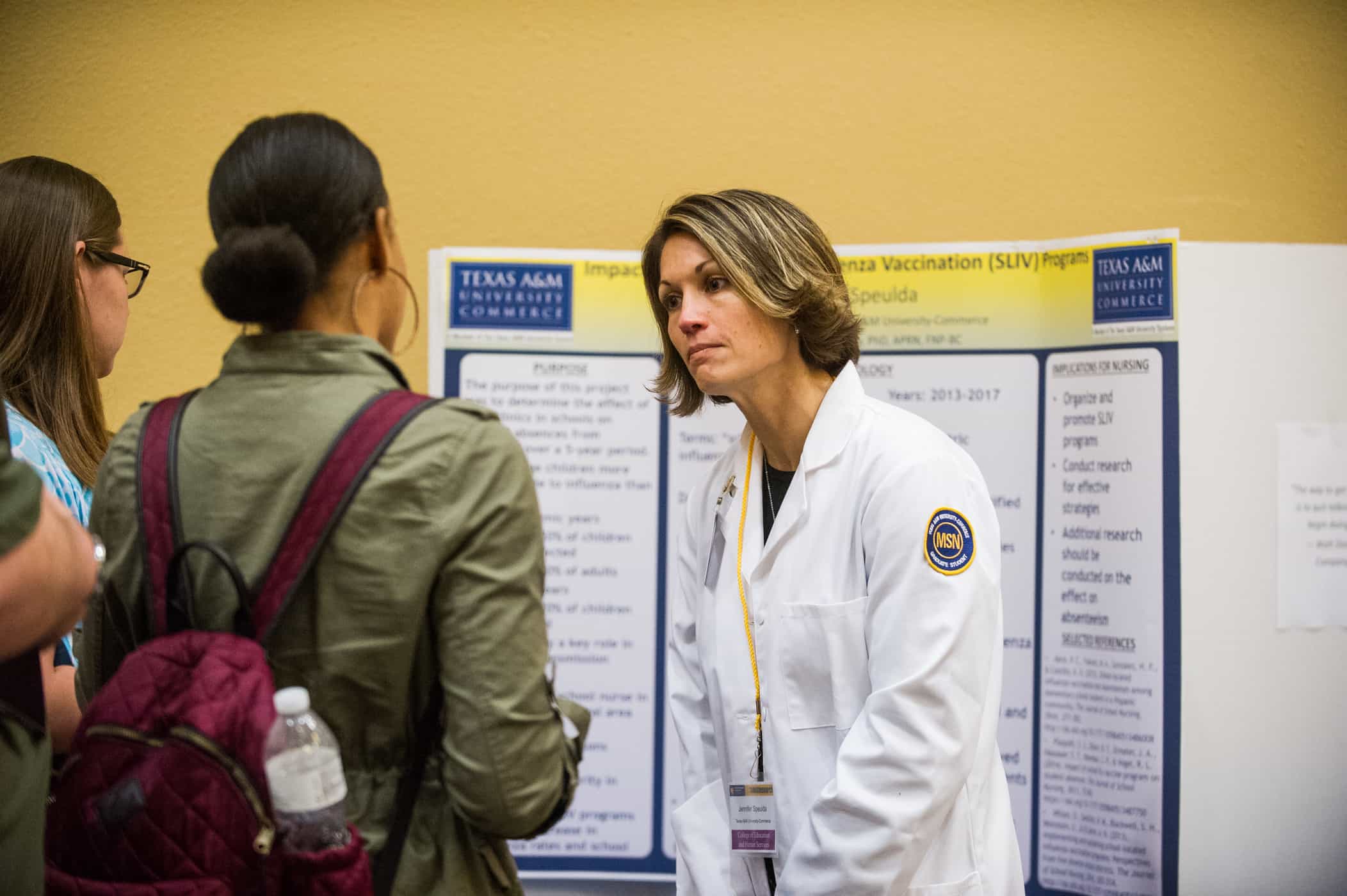 Two student asking a researcher