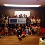 A group of students in a room with the university sign