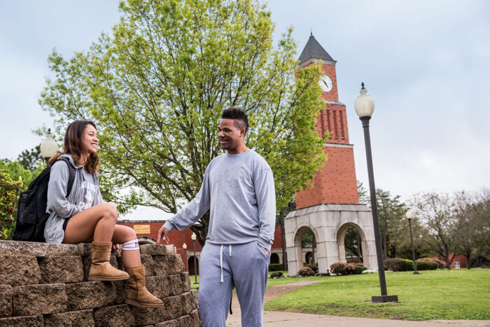 Two students talking in an outside space of the East Texas A&M campus at Navarro College.