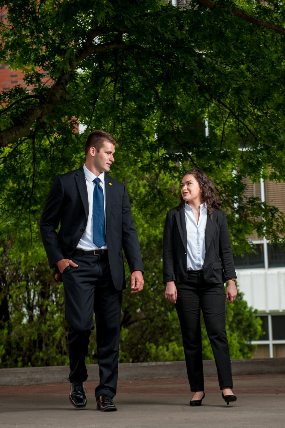 Two professionals having a conversation on a stroll down the side walk.