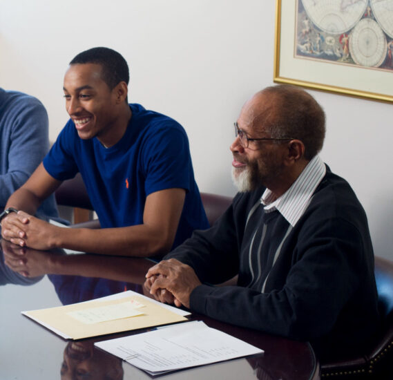 Two men around conference table.