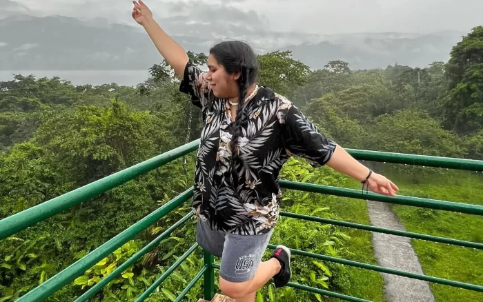 A female student making a pose on a balcony.