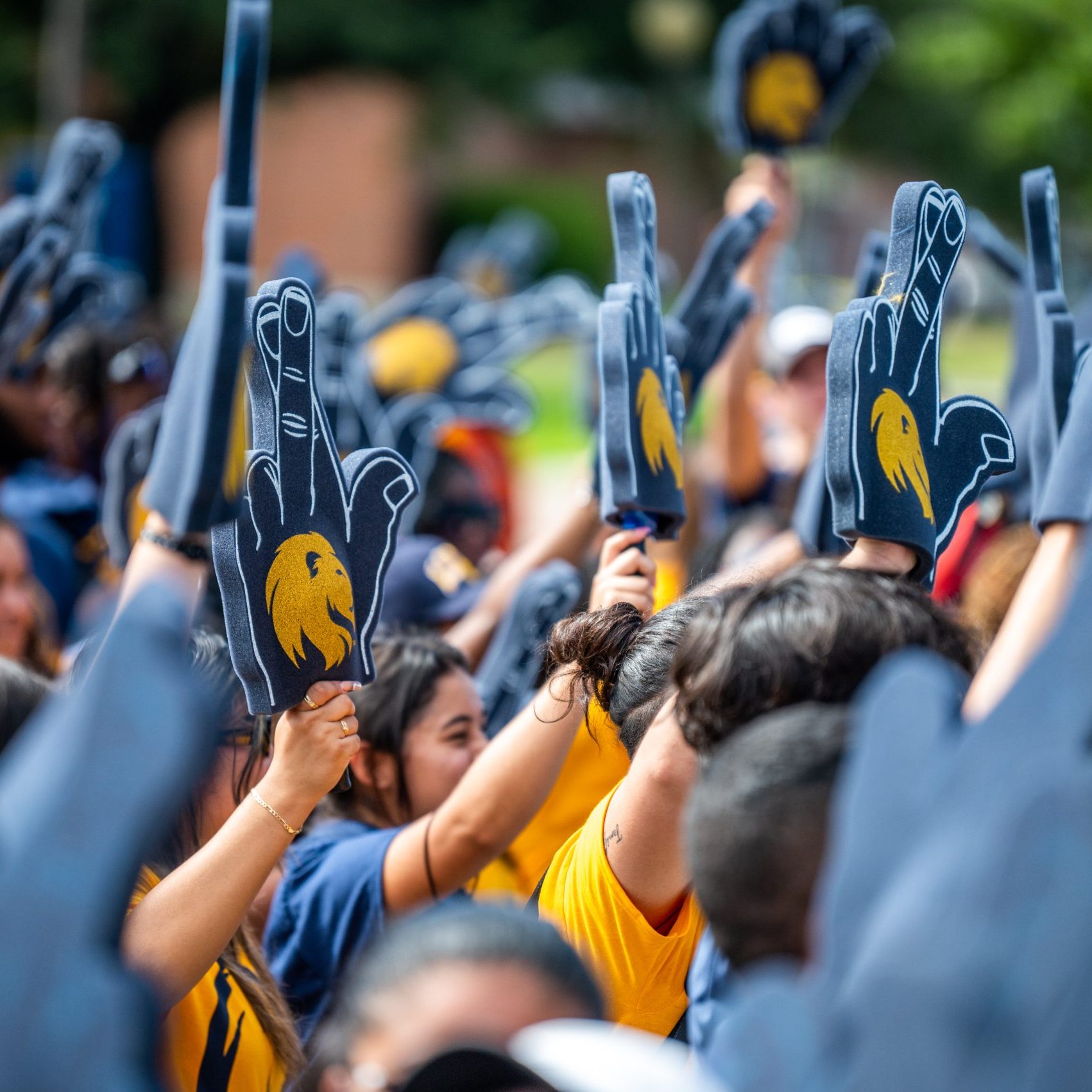 A group of student with the leo hand sign in the air.