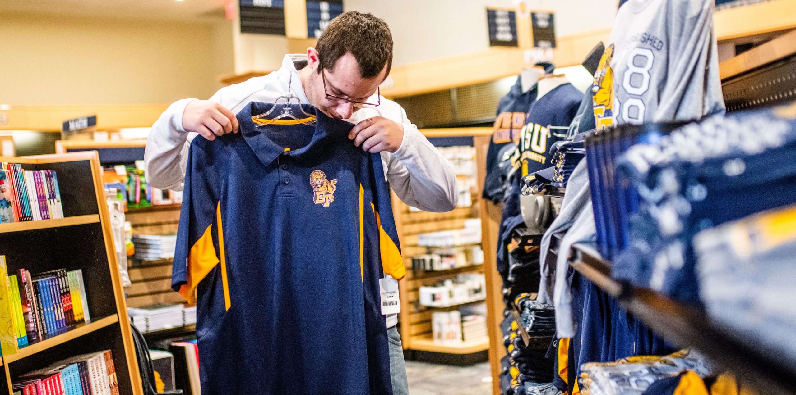 A male student looking at an East Texas A&M t-shirt.