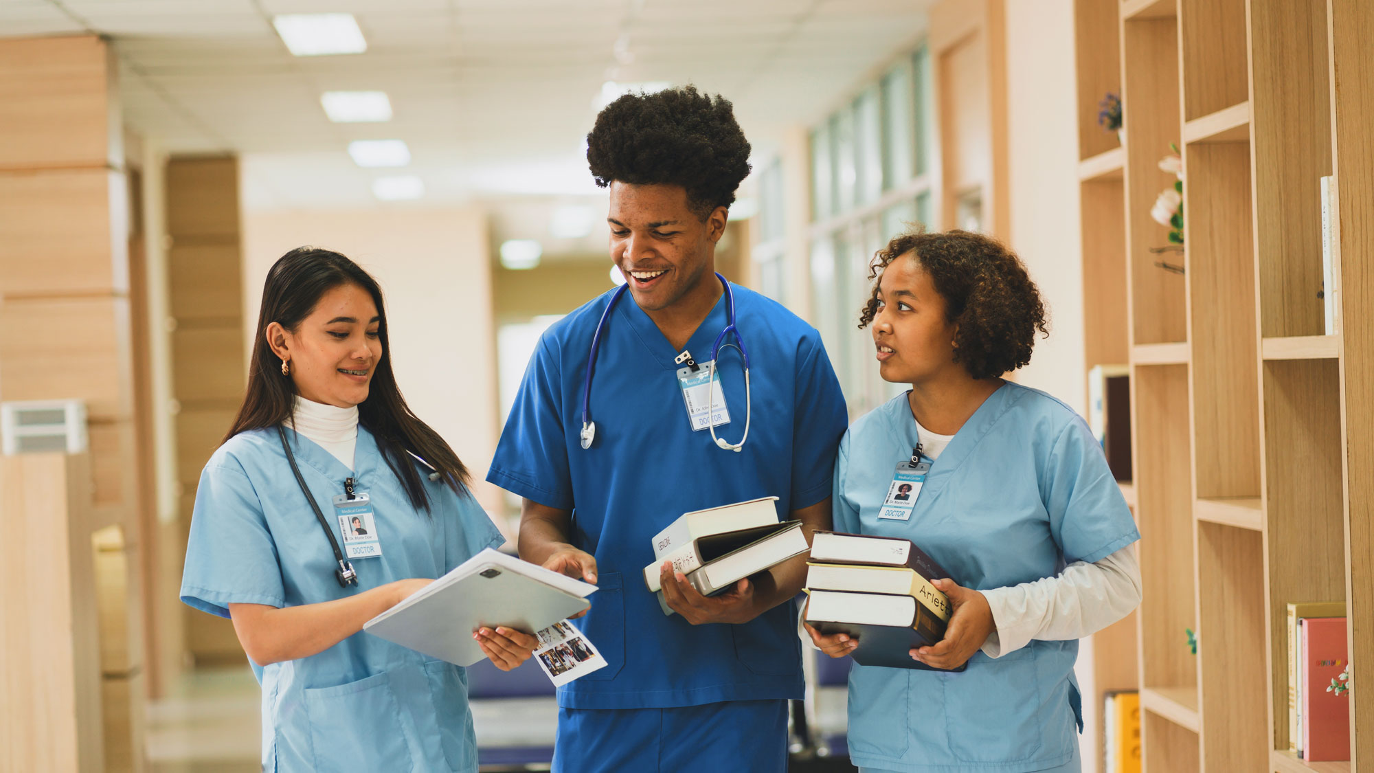 Nursing students at the hospital and pointing to papers.
