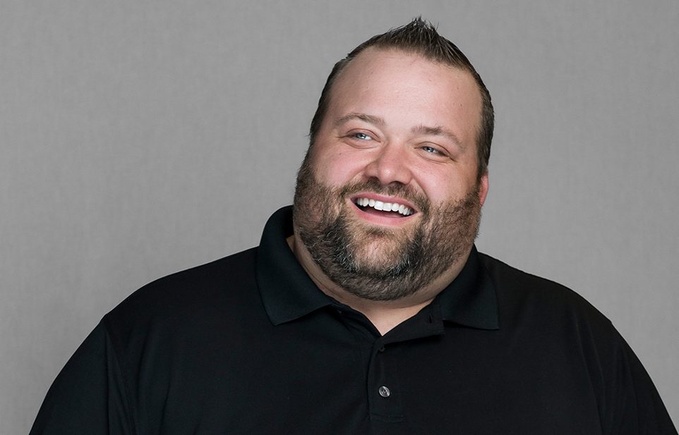 A man poses against a gray background.