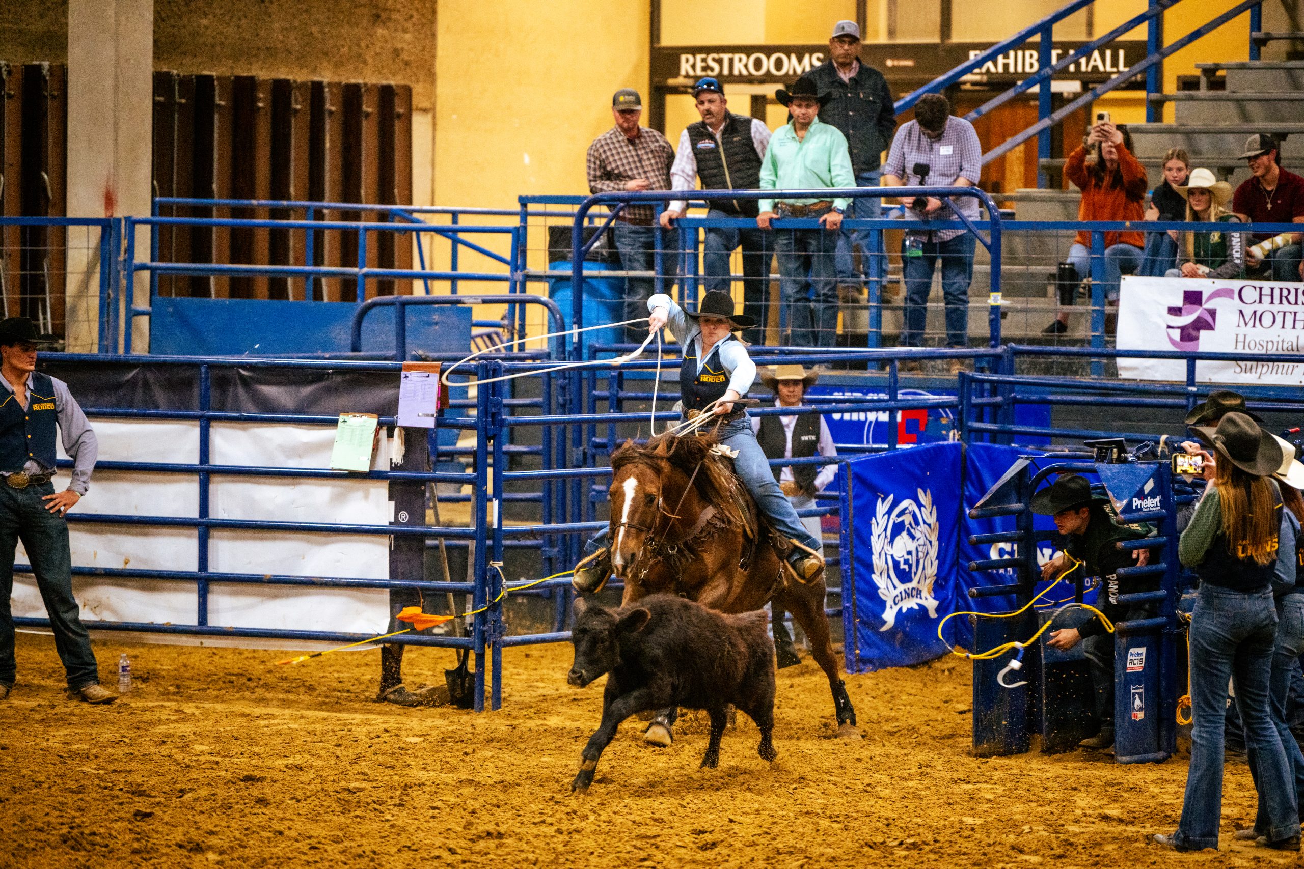 A male riding a horse at the rodeo.