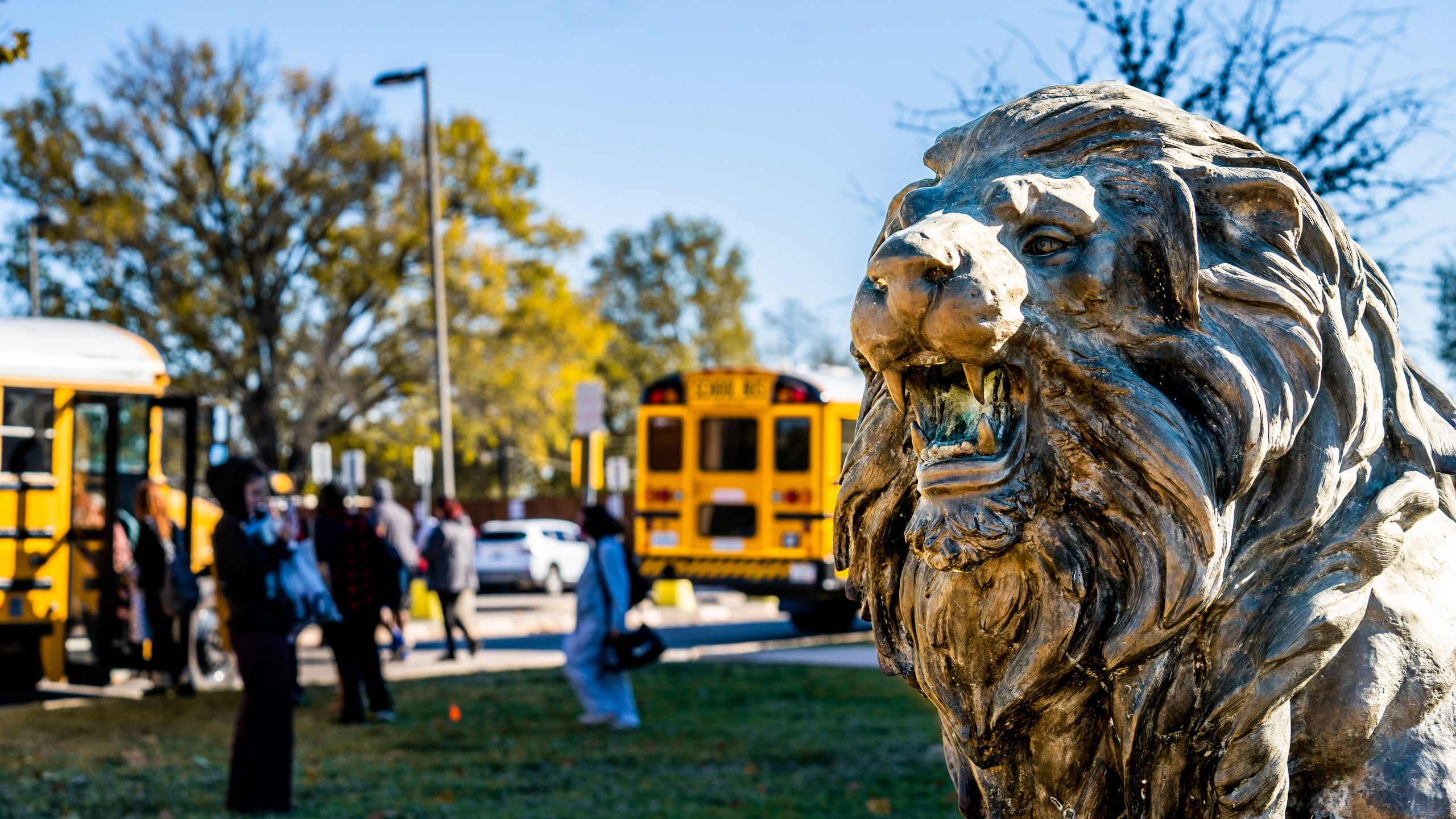 The lion statue with buses in the back ground.