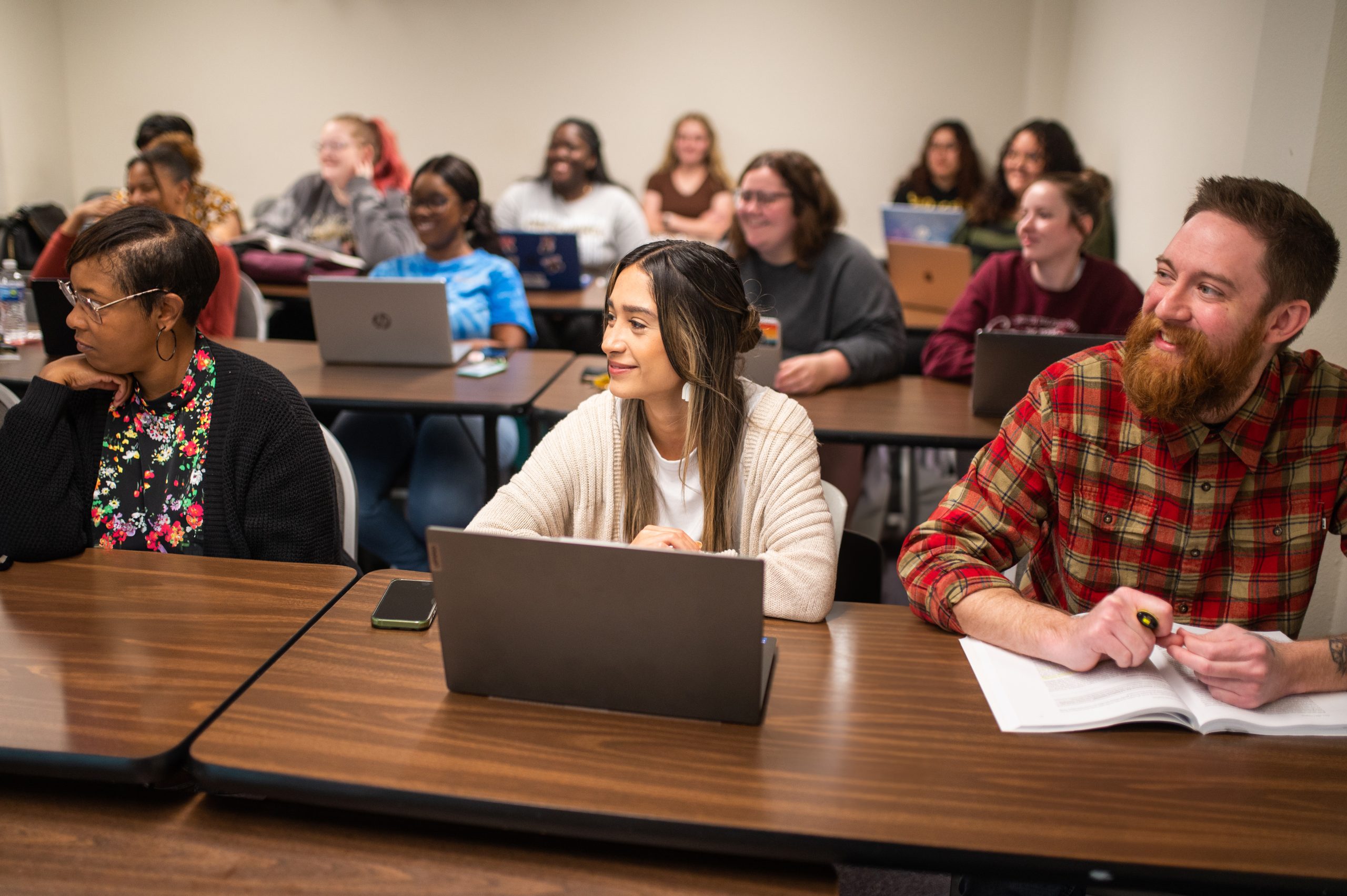 A group of student in the classroom looking to the front of the class. They appear engaged at the speaker.