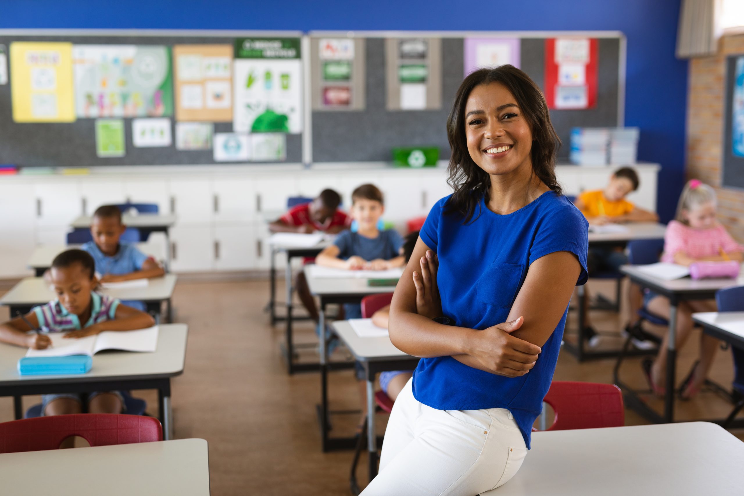 Teacher smiling in front of a classroom