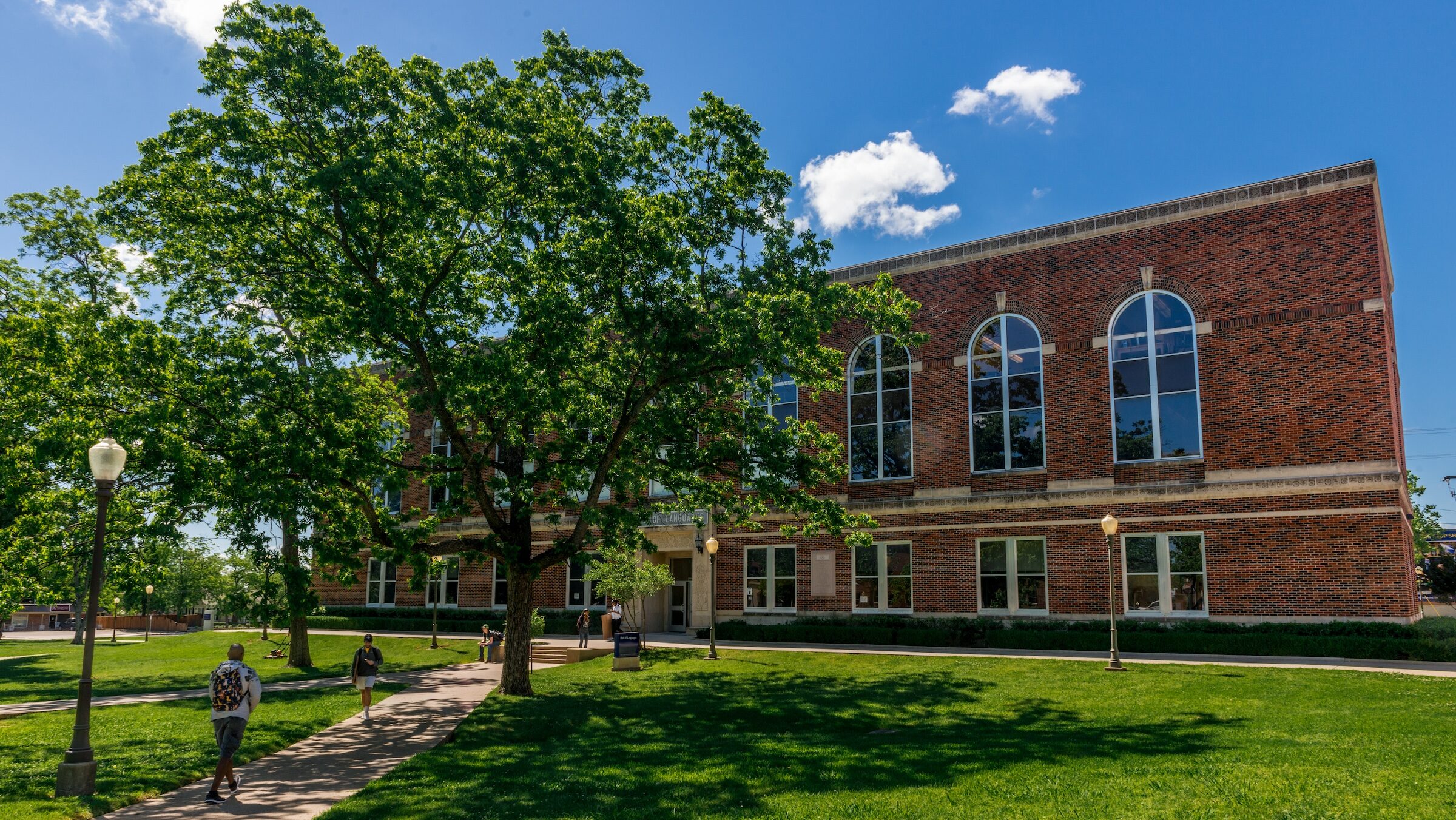 The exterior of a multi-story brick building on a college campus.