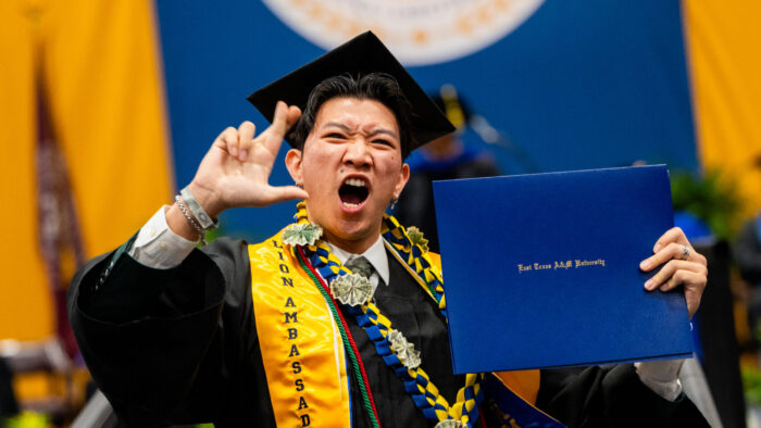 A college graduate celebrating after receiving their degree.
