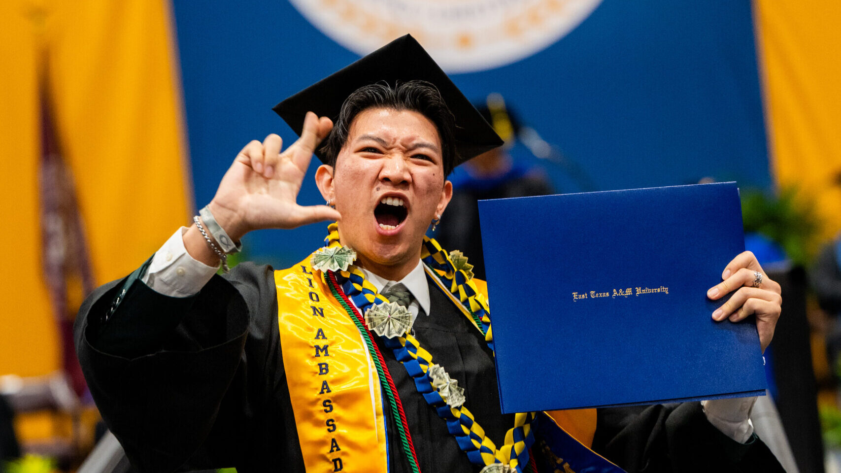 A college graduate celebrating after receiving their degree.