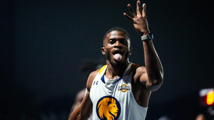 A track runner celebrates after winning a race.