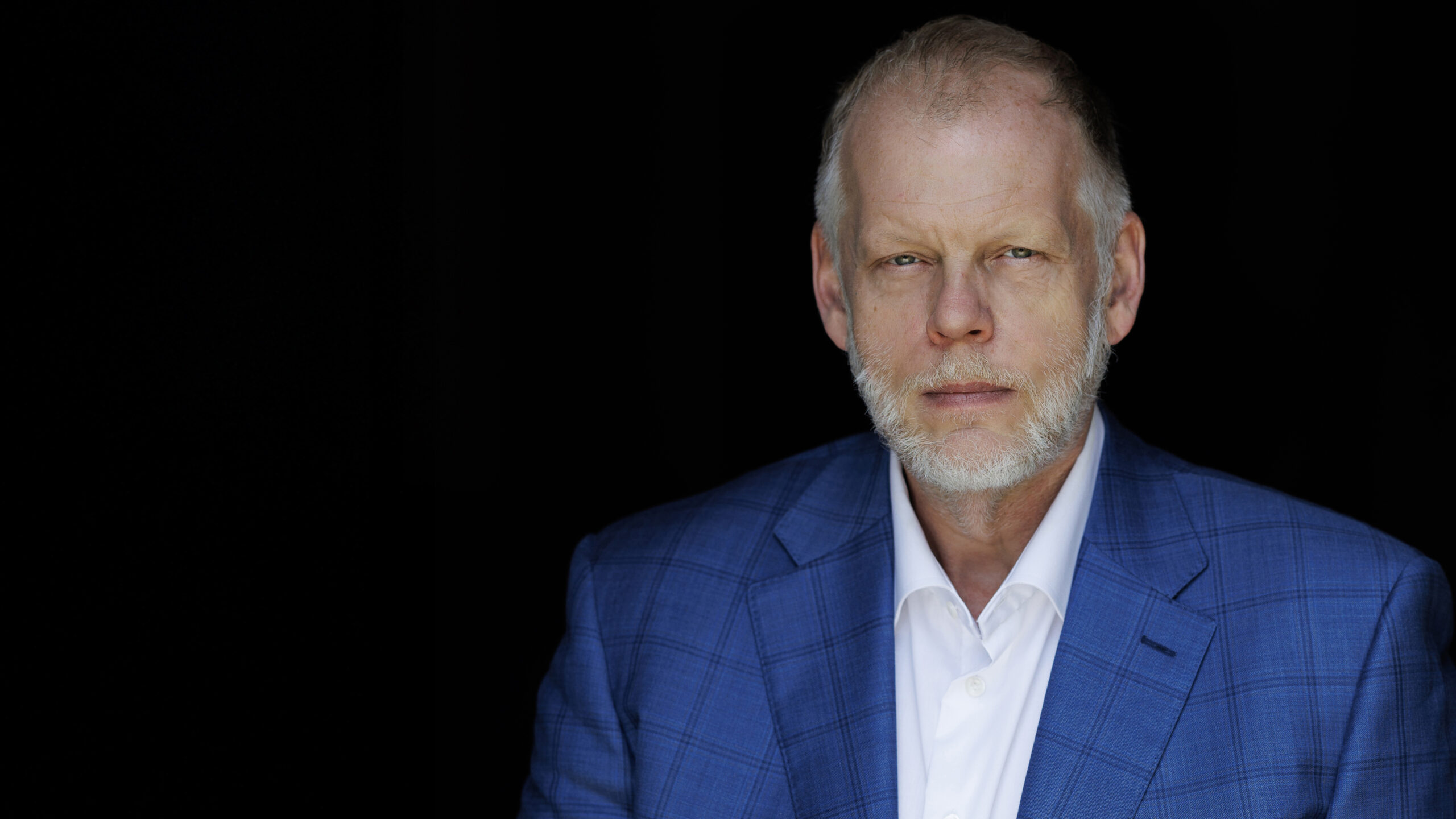 A headshot photo of a person in front of a black background.