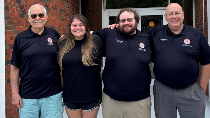 Four people posing side by side for a photo.