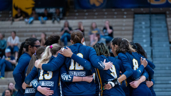 A team of volleyball players celebrating together after winning a point.