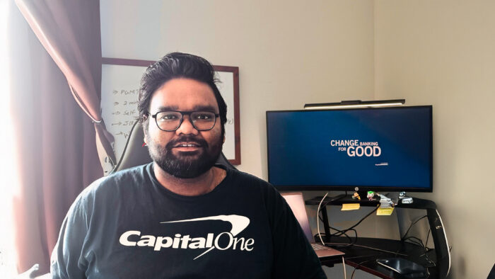 A person photographed while sitting in an office in front of a computer.
