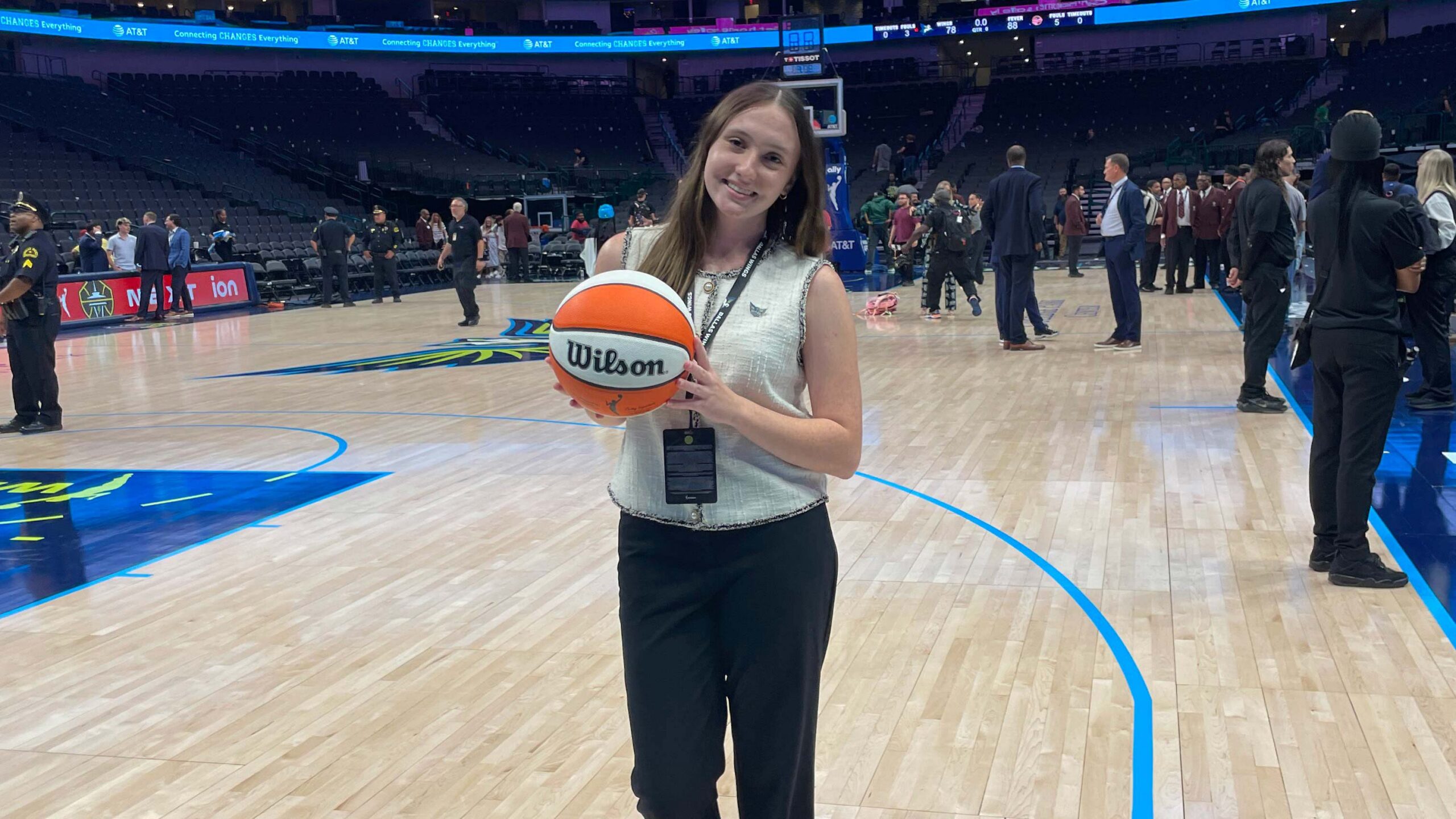 Woman holding a basketball on a basketball court.