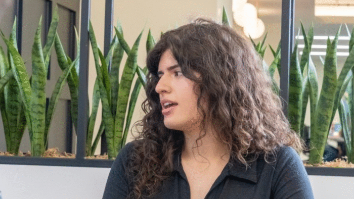 A person speaking in a meeting room.