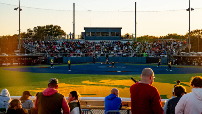 A softball stadium filled with fans watching a game.