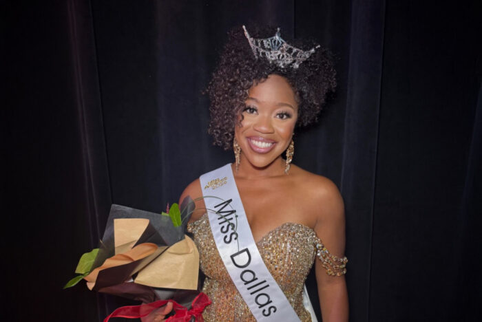 A pageant winner with sash and crown.