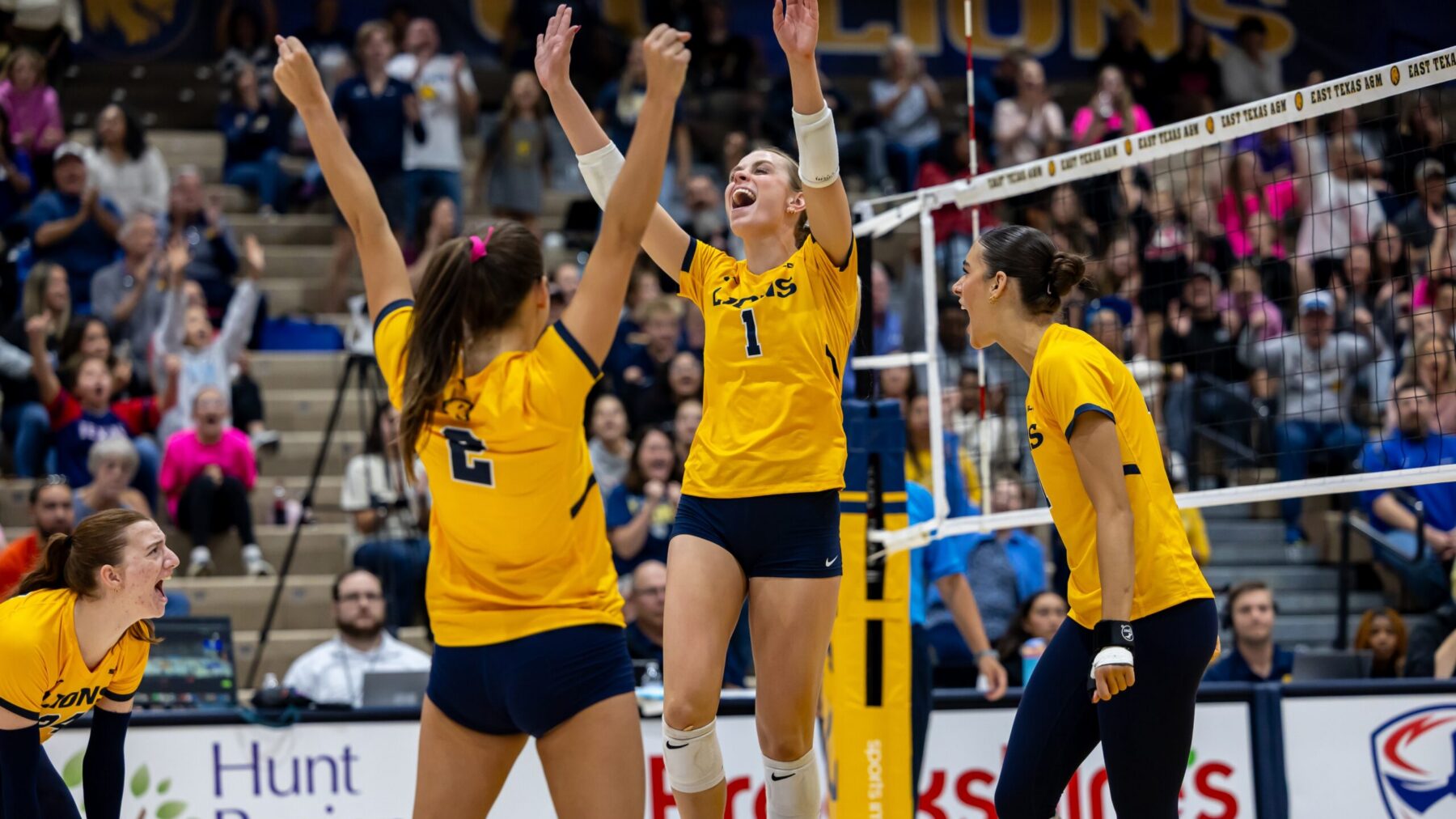 Volleyball players celebrate after scoring a point.
