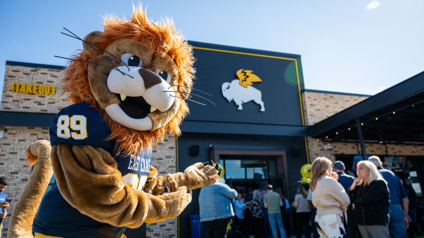 A lion mascot welcoming patrons to a restaurant.