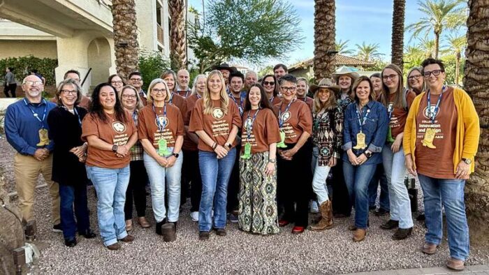 A group of people gathered outside, smiling at the camera.