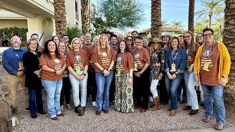 A group of people gathered outside, smiling at the camera.