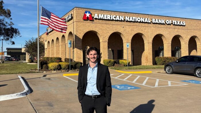 A person standing in front of a bank building.
