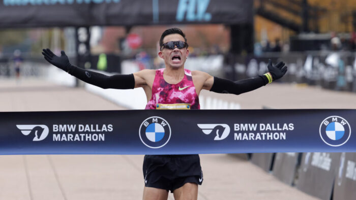 A runner crossing the finish line in a half-marathon.